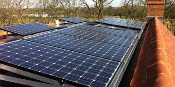 Man on roof installing PV Solar Panels