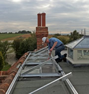 Man on roof installing bespoke design PV Solar Panels