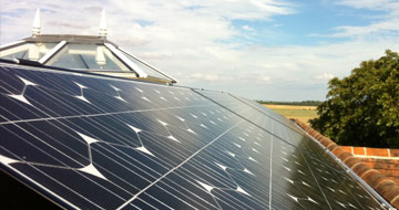 Man on roof installing PV Solar Panels